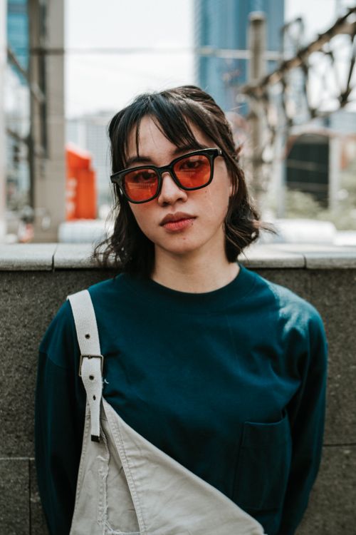 Free Portrait of a stylish young woman in sunglasses on the streets of Jakarta, showcasing modern street fashion. Stock Photo