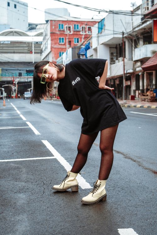 Free Young fashionable woman posing stylishly on an empty street in South Jakarta, Indonesia. Stock Photo