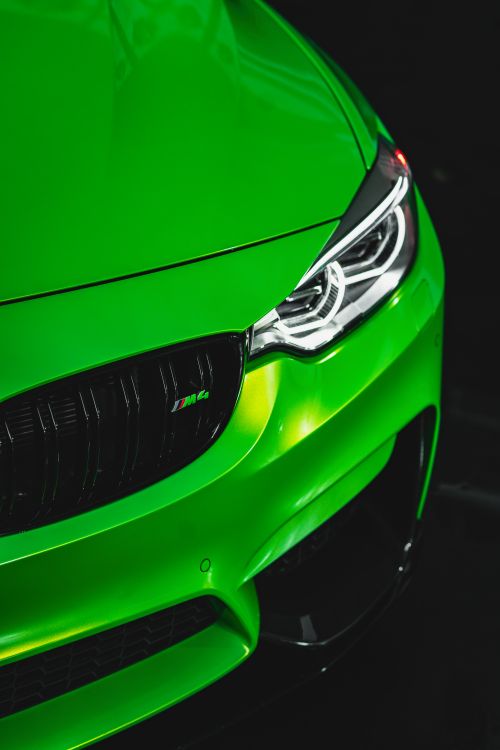 Free Close-up of a vibrant green sports car with focus on the headlight. Stock Photo