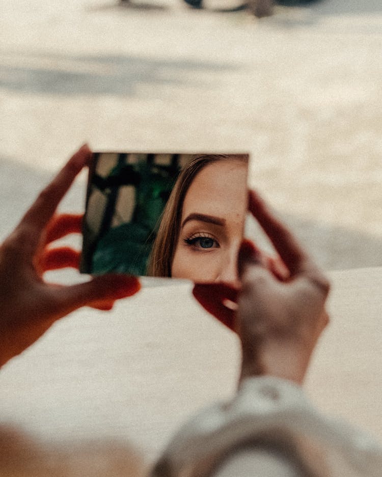 Woman In Makeup Looking In Mirror In Street