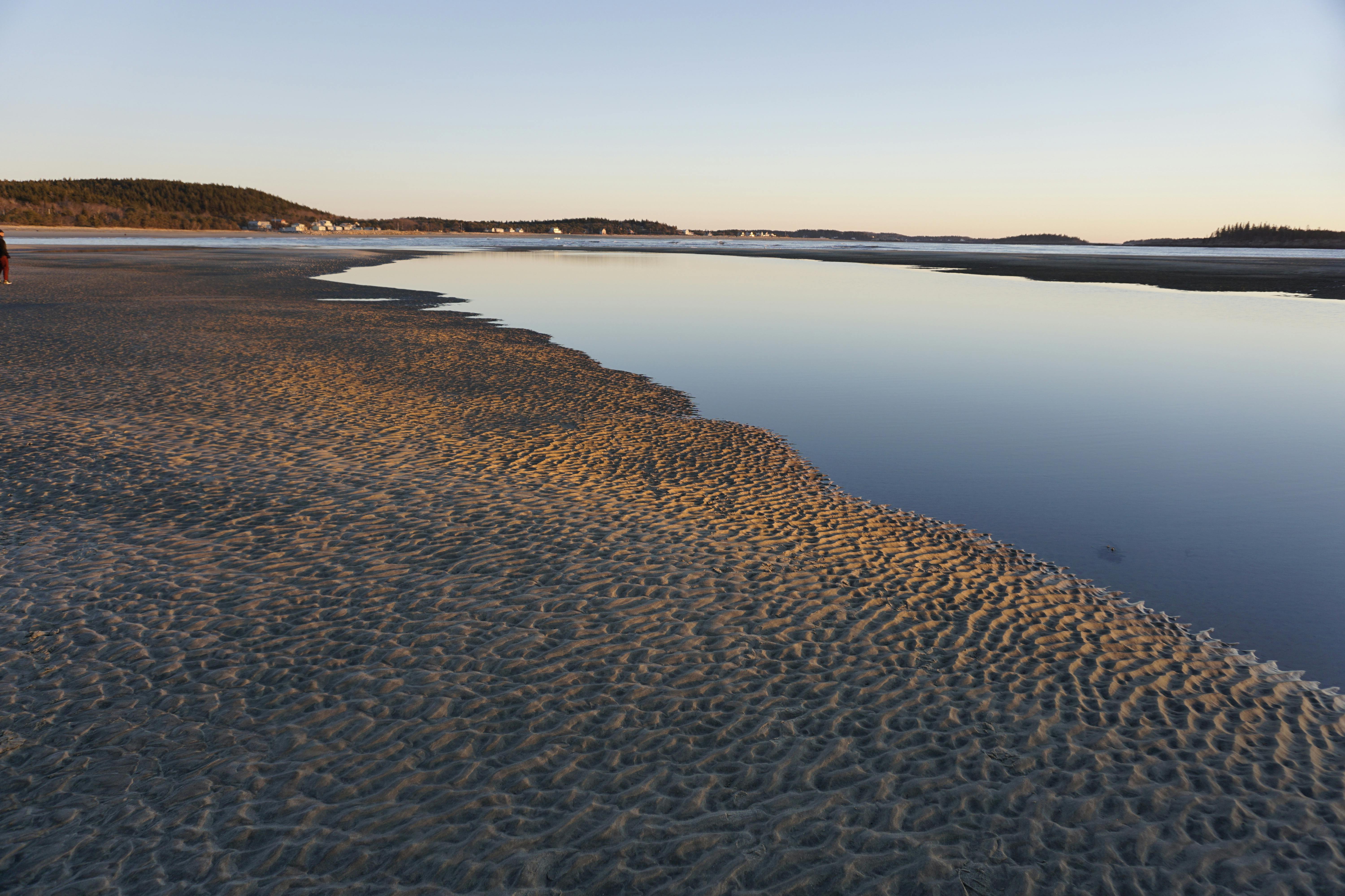 Scenic coastline at dawn with calm ocean and serene landscape, perfect for travel inspiration.