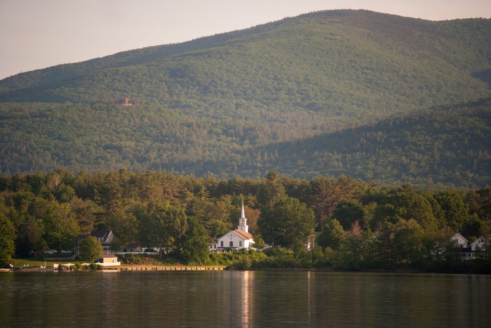 Picturesque church by lake with mountain backdrop in New Hampshire — Hollis NH small farming community character