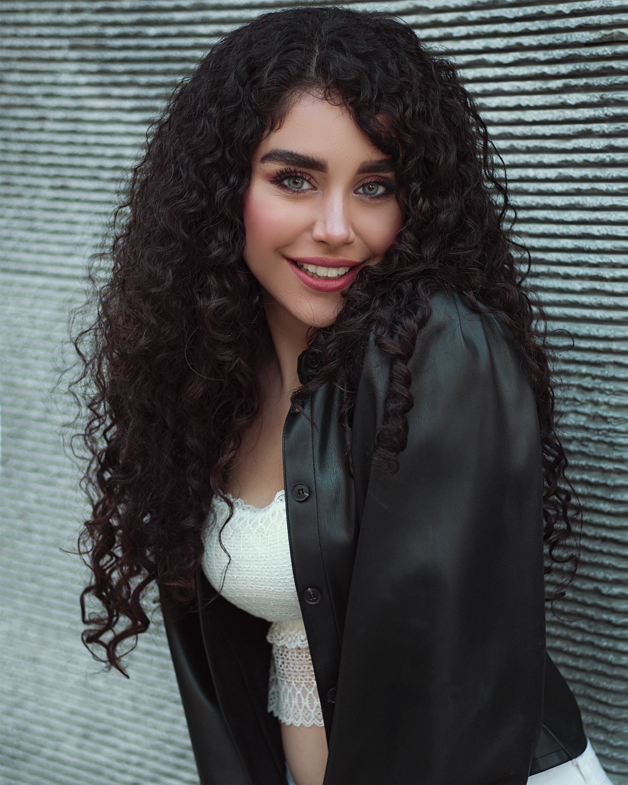 Portrait of a fashionable woman with curly hair and black leather jacket in Moscow.