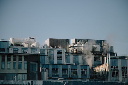 Factory building emitting smoke in industrial district