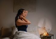一位平静的女人坐在舒适卧室的床上，享受着平静的时刻