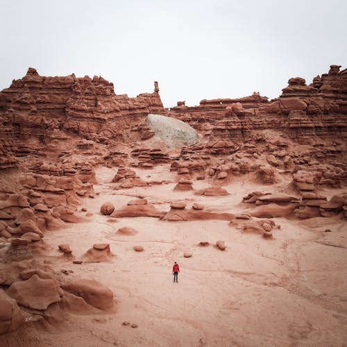 A Person Standing in the Middle of Rock Formations at the Goblin Valley State Park