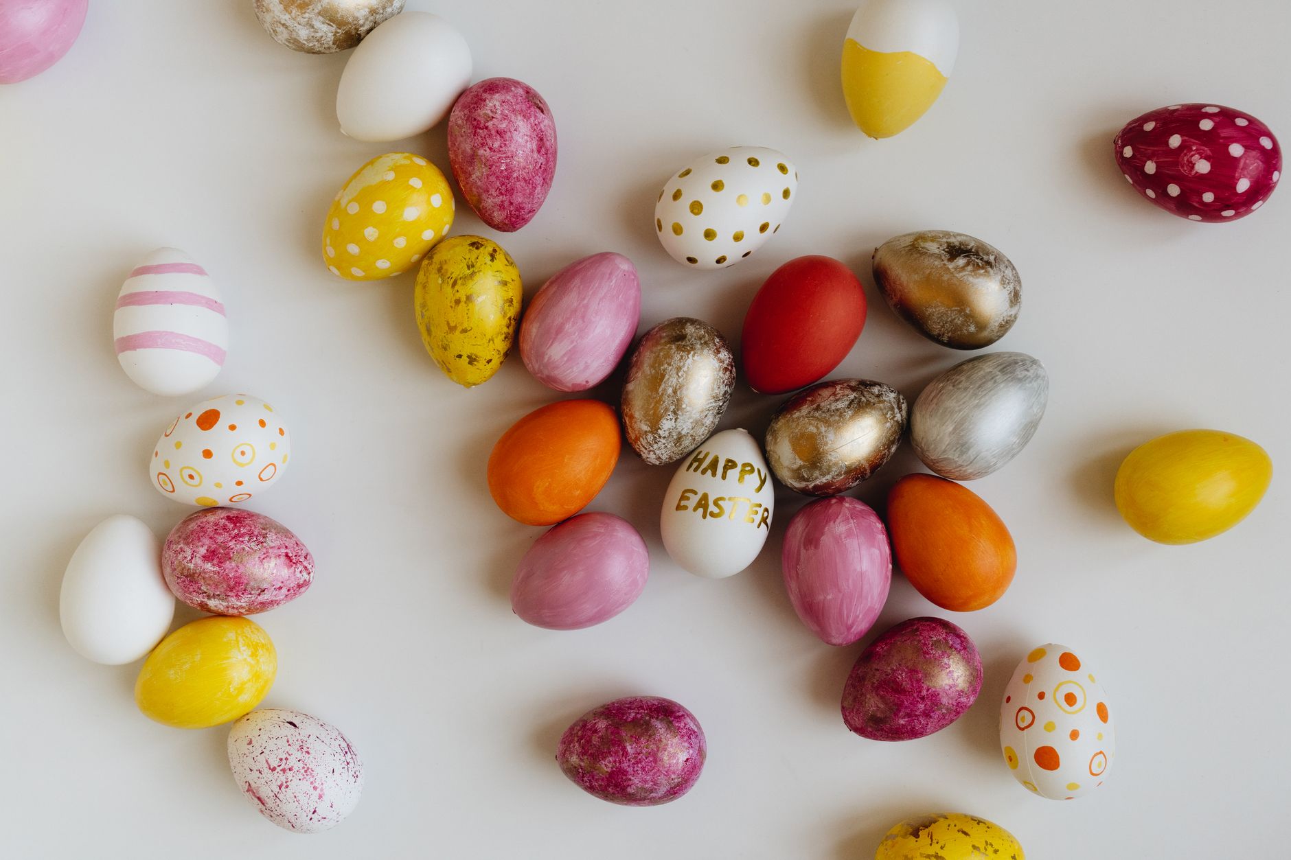 A collection of vibrant Easter eggs with varied patterns and colors on a white background.