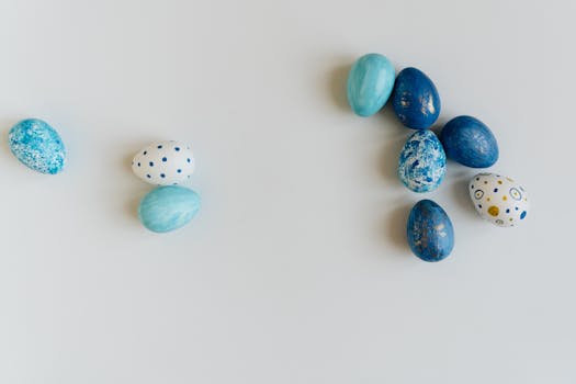 Close-up of decorative blue and white Easter eggs on a clean white surface, perfect for seasonal themes.