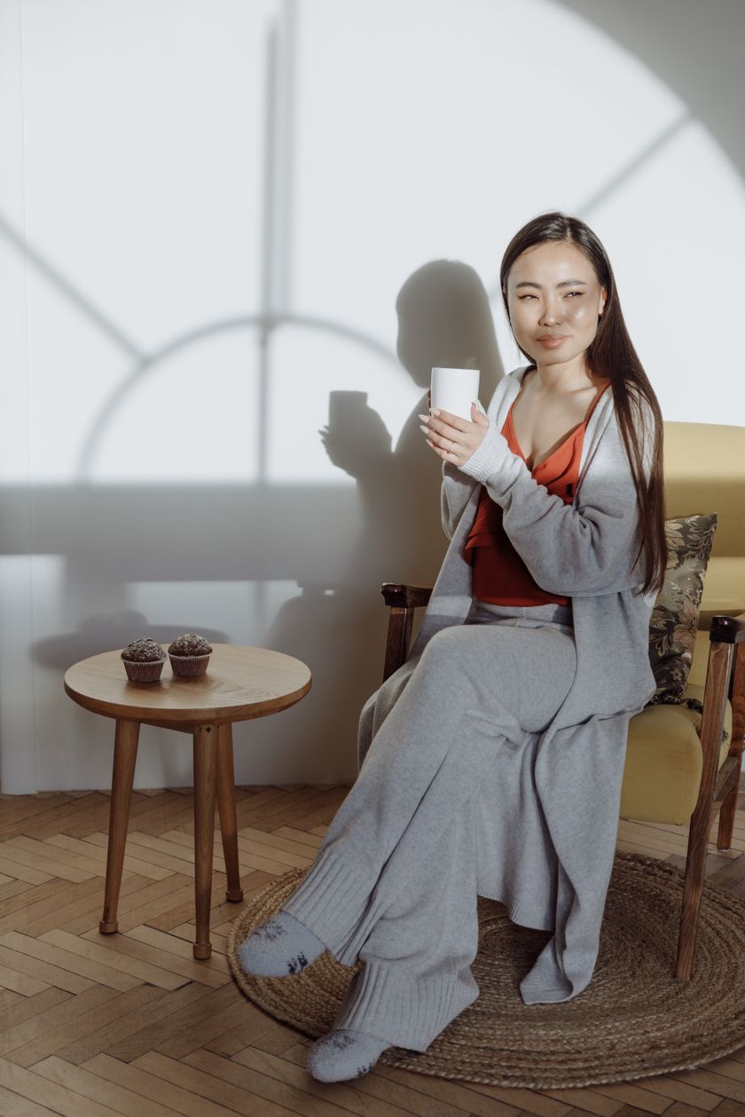 Woman at home in a grey loungewear set — knit top and wide matching trousers.