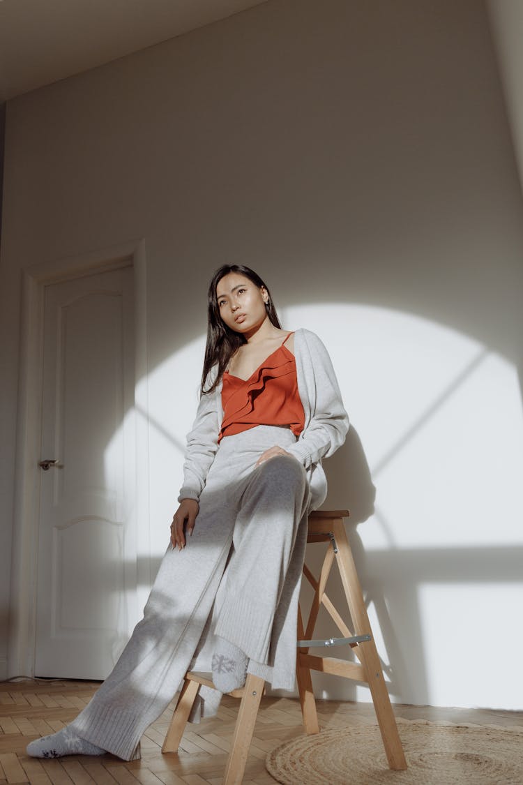 Woman Sitting On A Stool Beside A Door