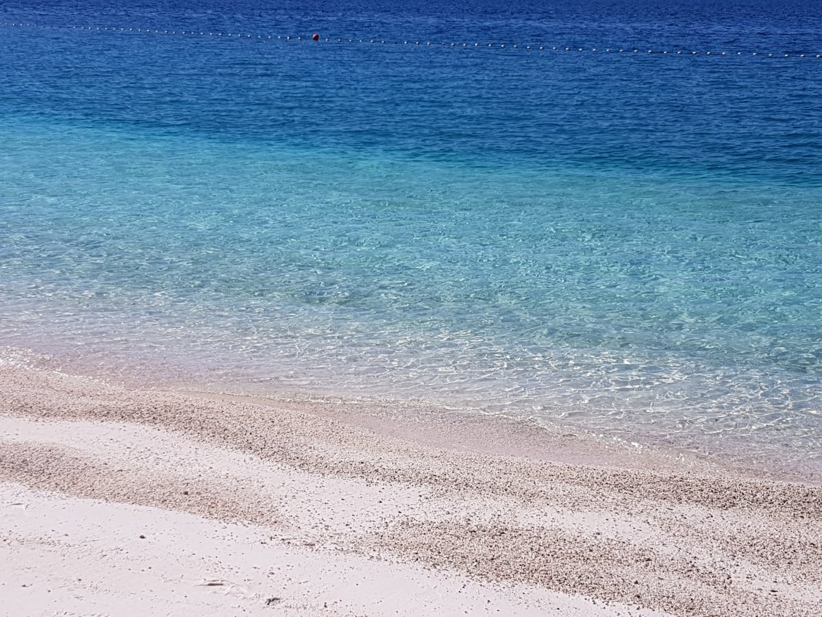 Person browsing clothes on a rack in a cozy thrift or vintage shop