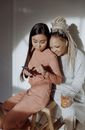 Women in Loungewear Sitting on a Wooden Chair while Having Conversation