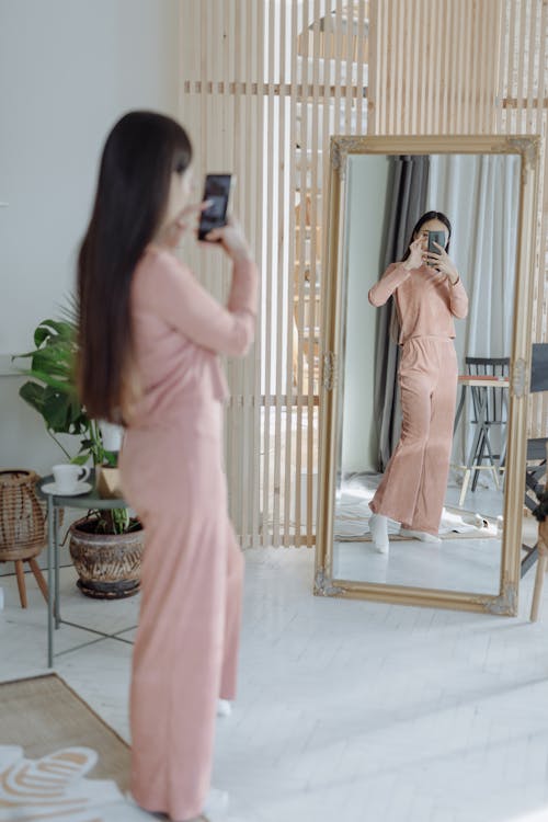 Free A Woman Taking Selfie in Front of the Mirror Stock Photo