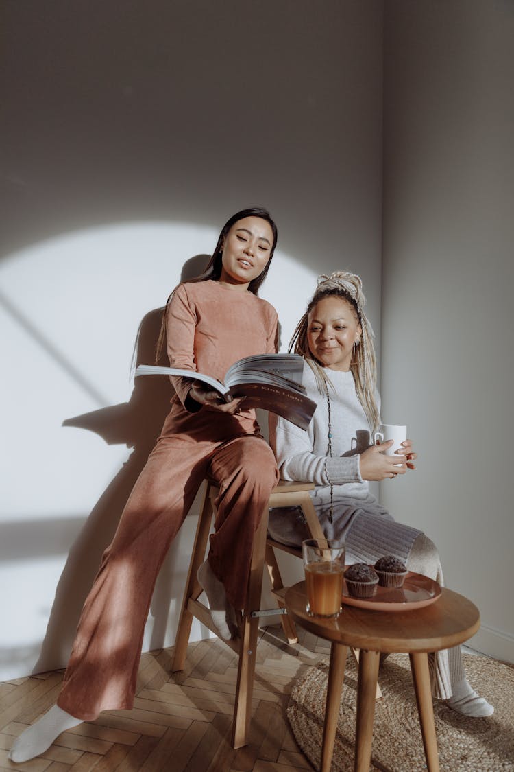 Women Having Conversation While Looking At The Magazine