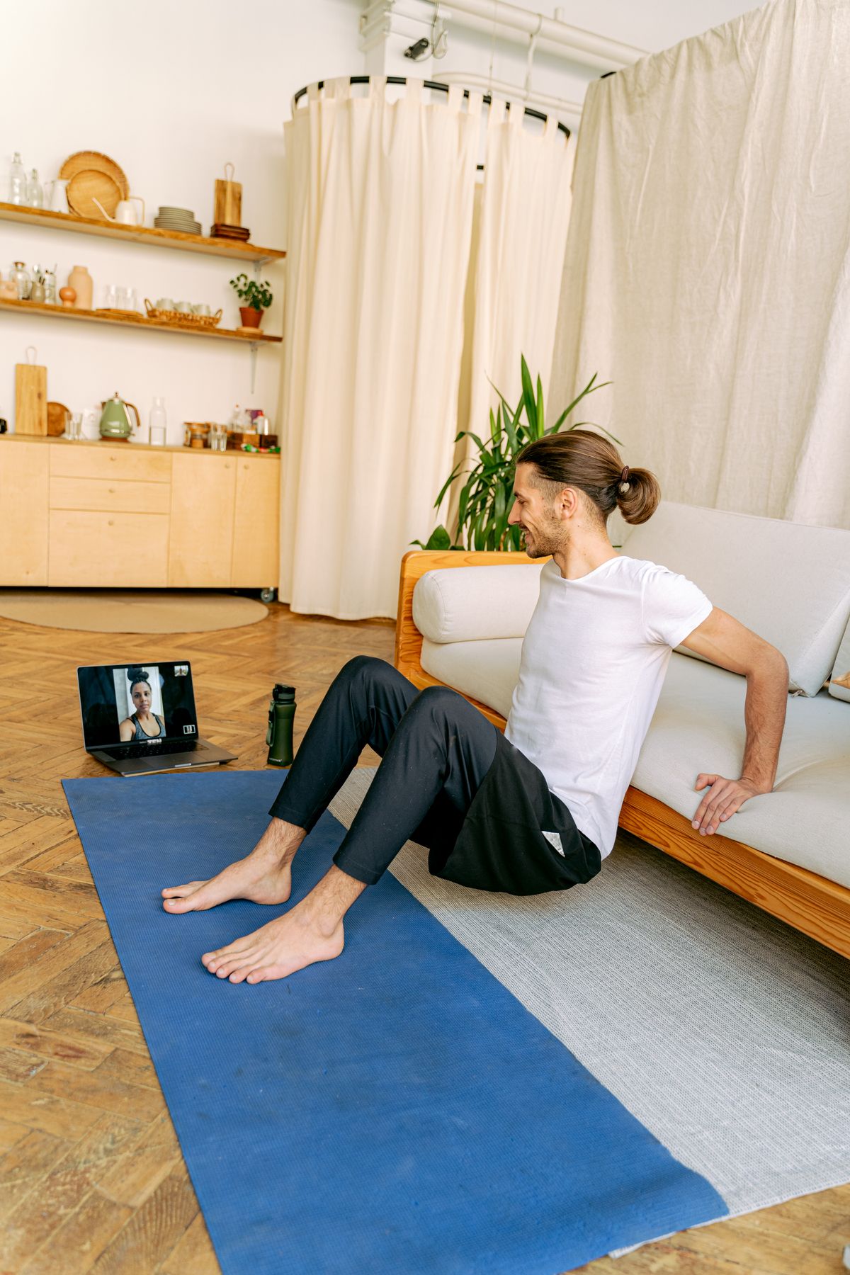Man doing a workout exercise at home during a video call