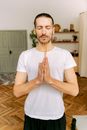 A Man in White Shirt Meditating while Holding an Incense Sticks