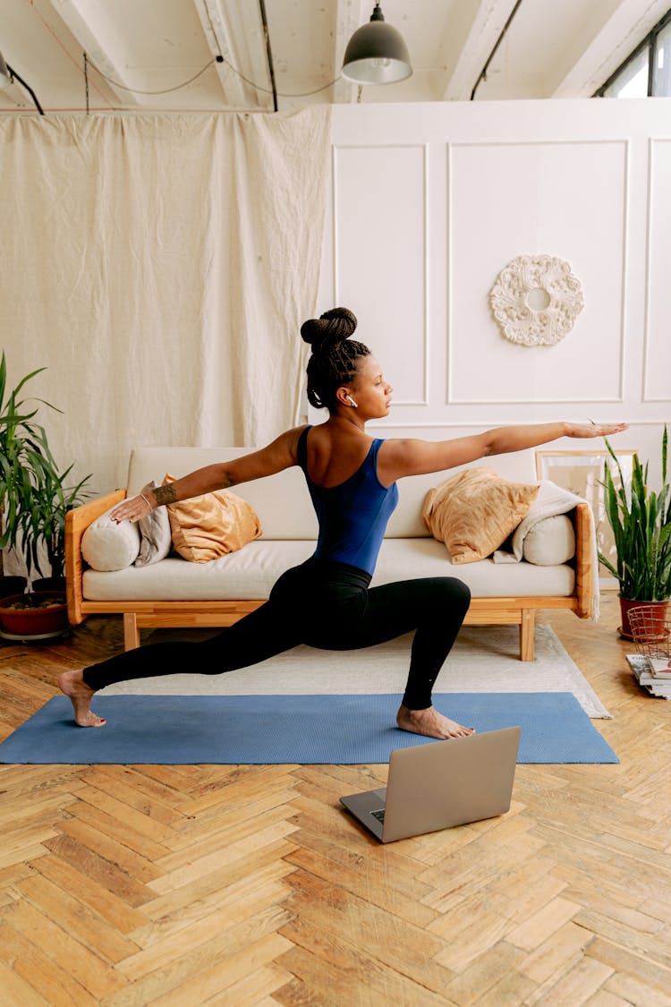 A Woman Doing Yoga While Wearing Earbuds