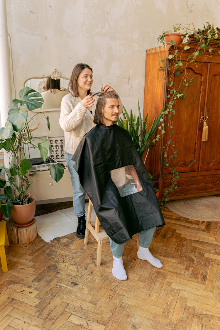 Woman Doing Hairstyle For Man In Retro Interior