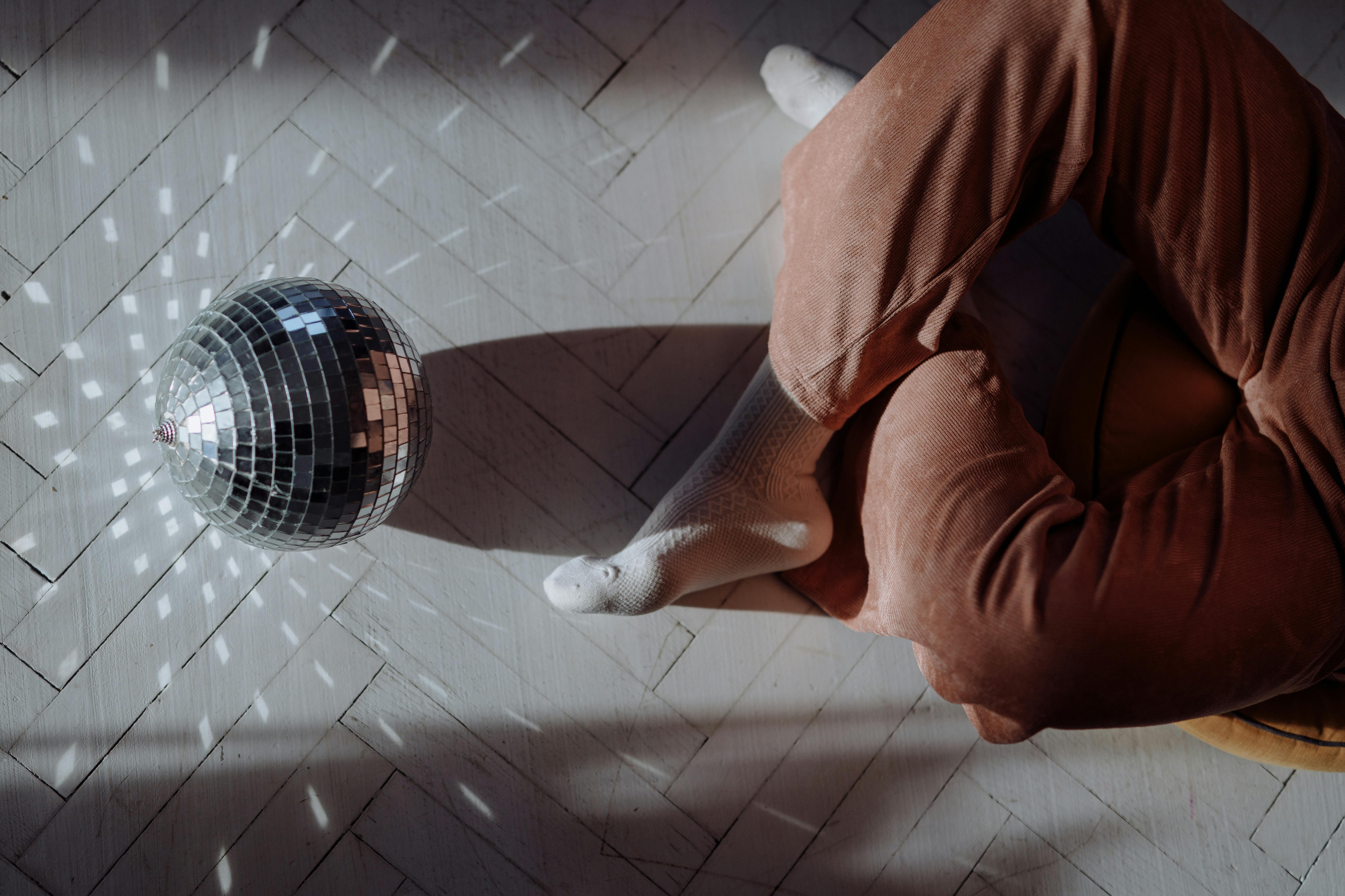 a disco ball and a person sitting on the floor