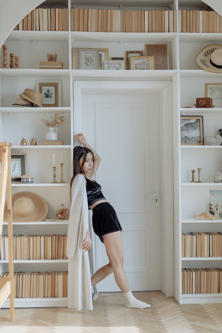 Woman Leaning On Shelves Around Door