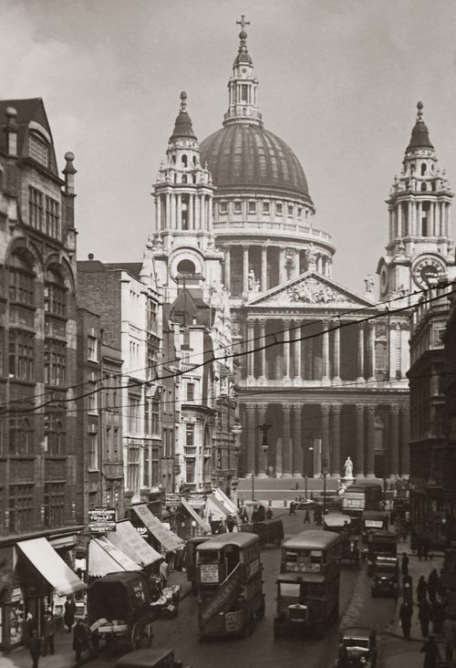 Free Vintage photograph depicting St. Paul's Cathedral in London with classic vehicles and bustling street life. Stock Photo