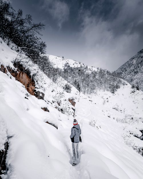 A Person Hiking a Snow Covered Mountain