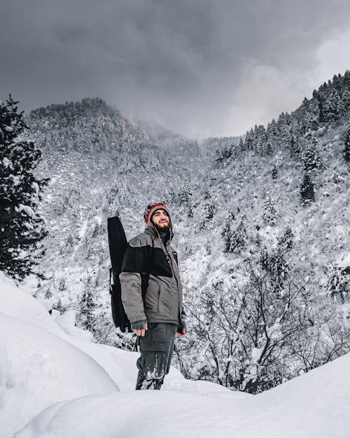A Man Standing in a Snow Covered Mountain