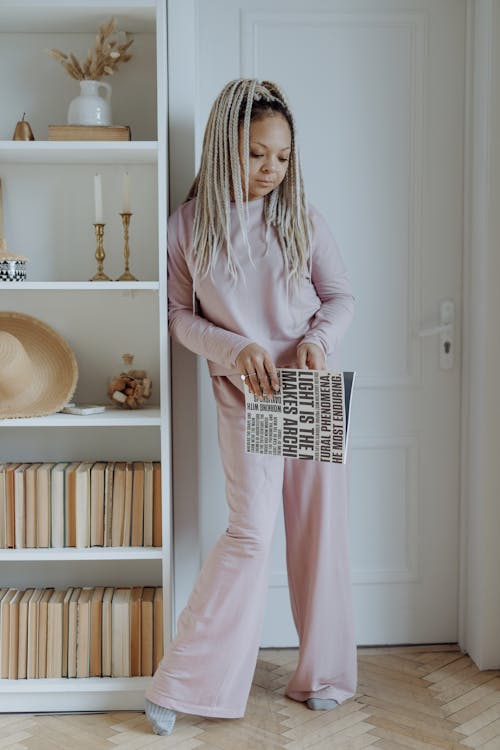 Free A Woman with Dreadlocks Hair Holding a Book Stock Photo