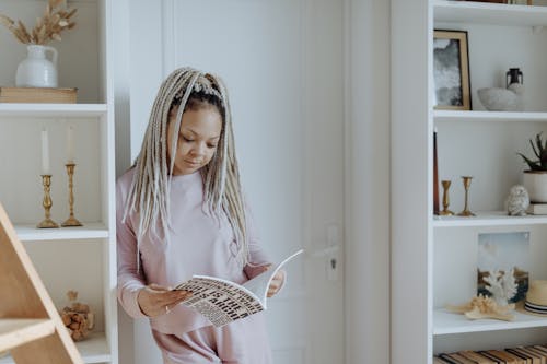 Free A Woman Reading a Book Standing Stock Photo