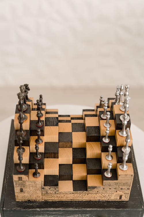 A Unique Metal Chess Set on a White Table