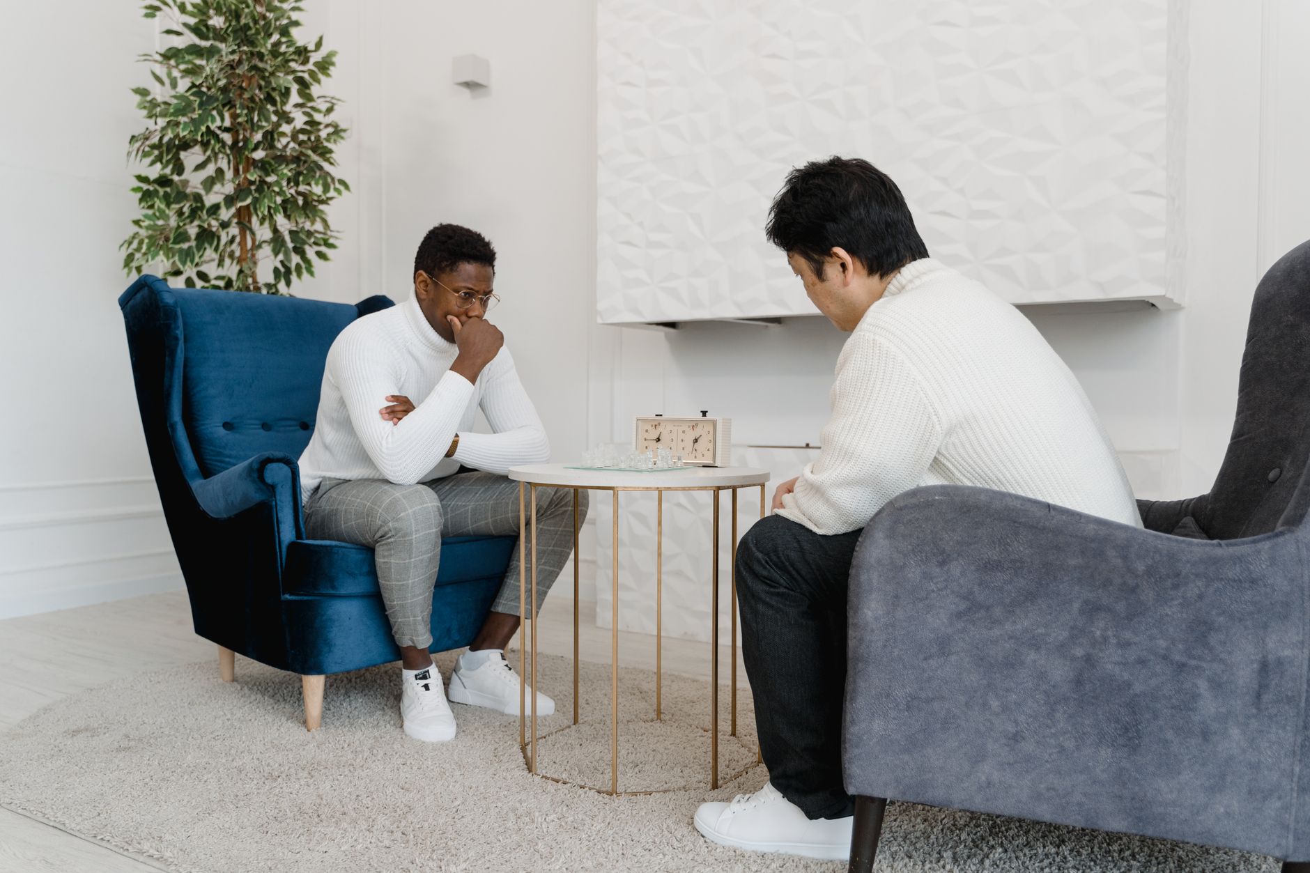 Men Sitting Looking at a Chess Clock