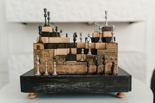 Free Capture of an abstract, artistic chess set with unique wooden and metal pieces. Stock Photo