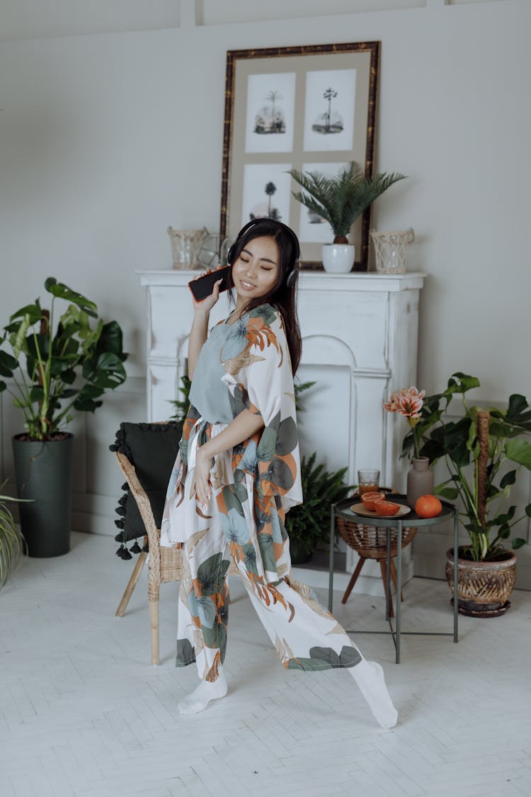 A Woman Dancing In The Living Room Near The Fireplace