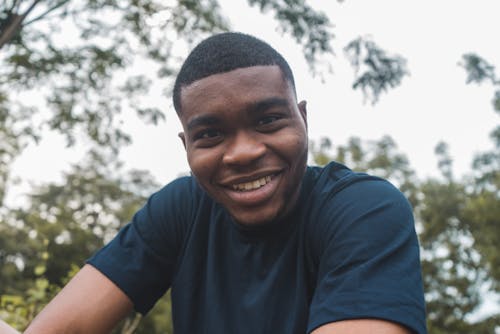 A Smiling Man Wearing a Blue Crew Neck T-shirt 