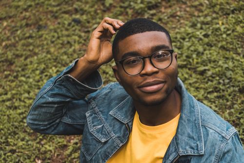Free Confident young man in glasses and denim jacket outdoors in Abuja. Stock Photo