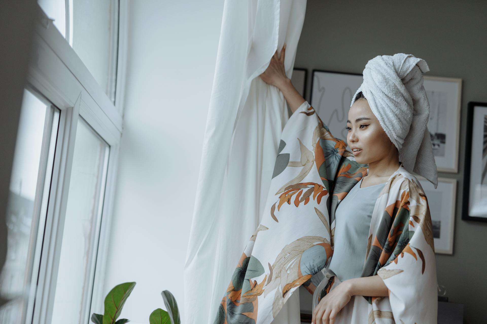 Woman in Silky Pajama and Towel on Head Opening Curtains