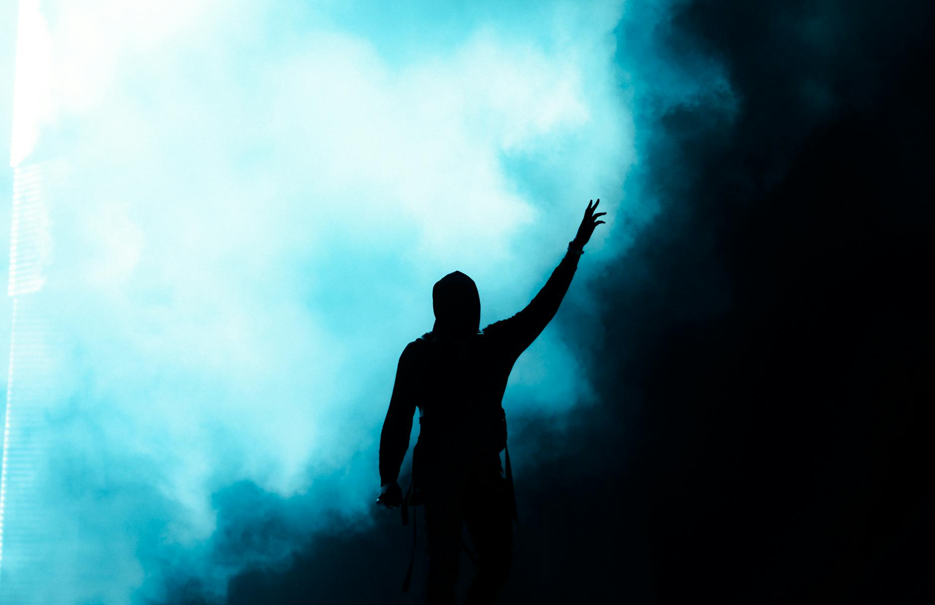 Fight between evil and good and victory over flaws shown by anonymous figure raising hand with hope from darkness