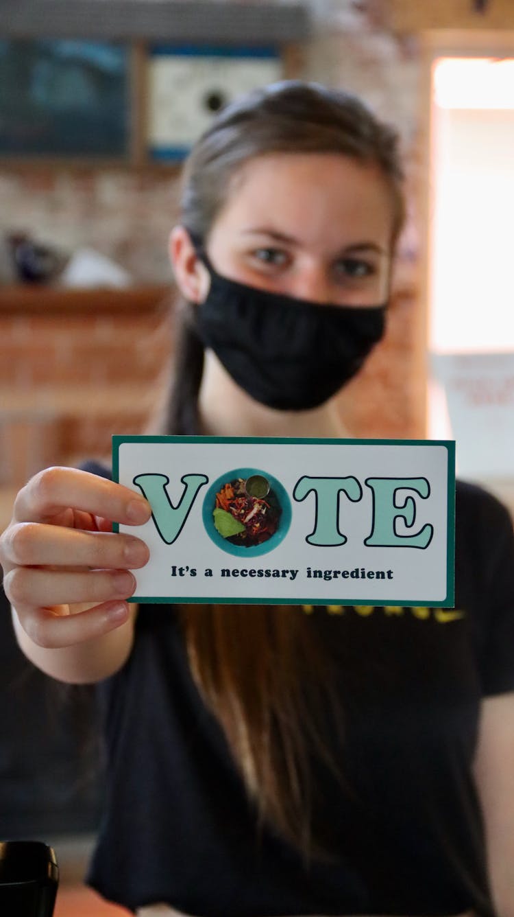 A Woman Holding A Vote Card