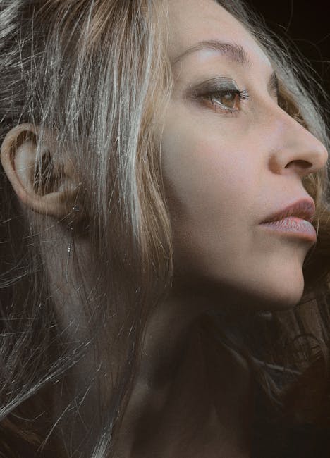 Close-up side profile portrait of an elegant woman with long flowing hair.
