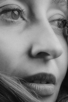 Detailed black and white portrait of a woman's face focusing on eyes and lips.