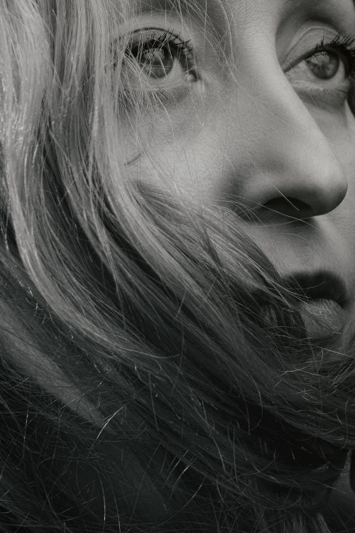 Free Elegant black and white close-up portrait of a woman with flowing hair. Stock Photo