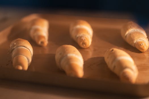Golden brown croissants freshly baked on a tray, perfect for breakfast or a snack.