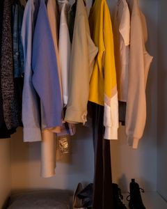 A stylish collection of clothes and shoes neatly arranged in a closet.