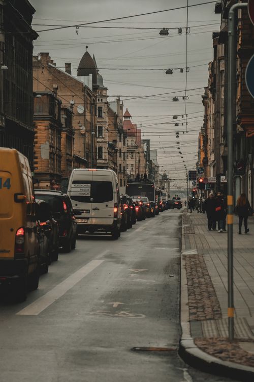 Free Traffic congested street in Riga, Latvia, showcasing a cloudy skyline and architectural buildings. Stock Photo