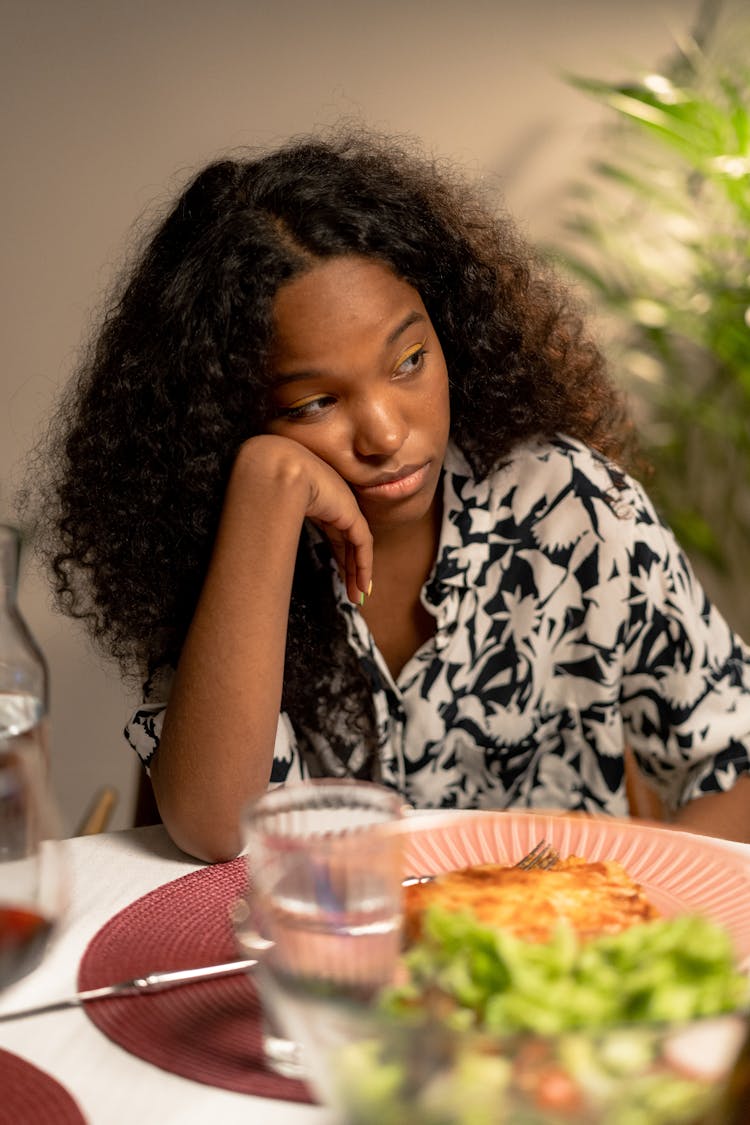 A Woman In Printed Shirt Leaning On The Table