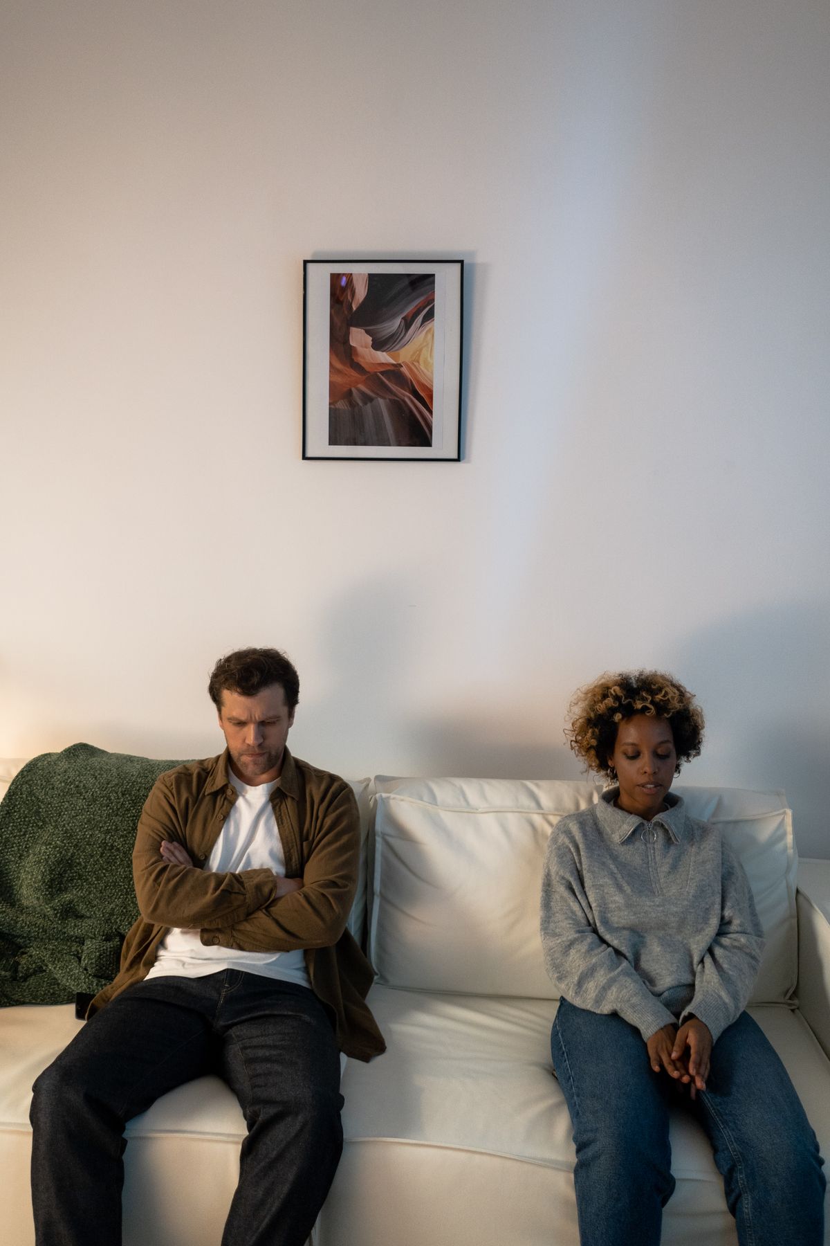 My Partner Has Bad Breath and Telling Them Did Not Change Anything 1 Couple sitting apart on a sofa in silence after one told my partner about their breath