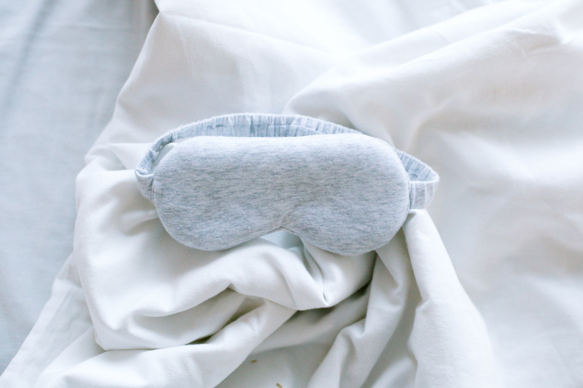 A Gray Garterized Eye Cap on a White Textile