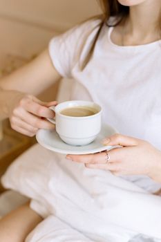 Person enjoying a warm cup of coffee in a calm indoor setting, perfect for relaxation.