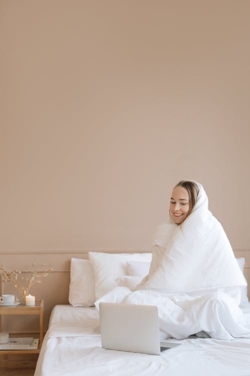 Free A Woman Wrapped with a Blanket while Watching on a Laptop Stock Photo