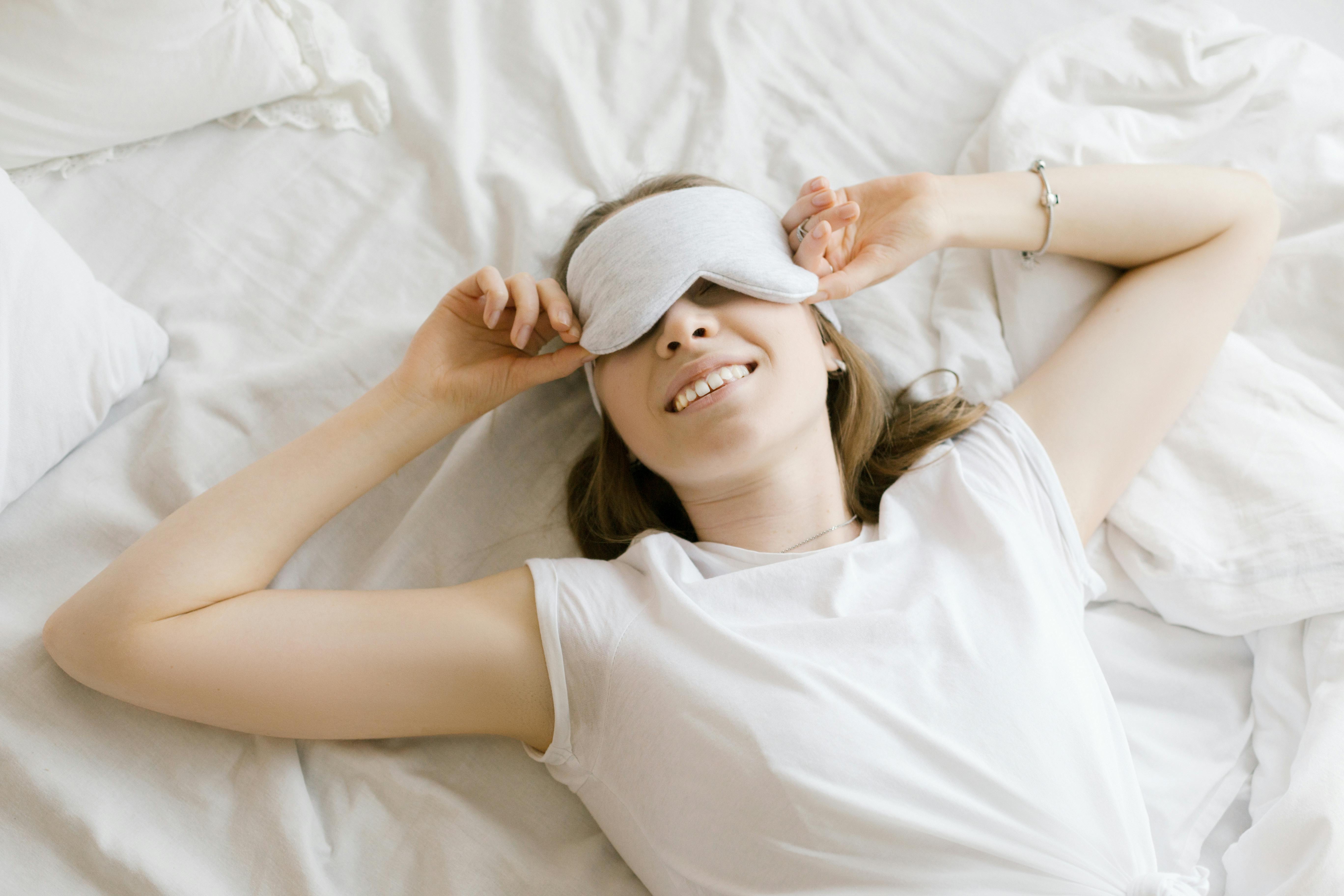 woman in white shirt lying on bed